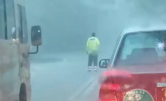 清水灣暴雨突現水浸，交通警冒雨指揮車流。網上片段截圖