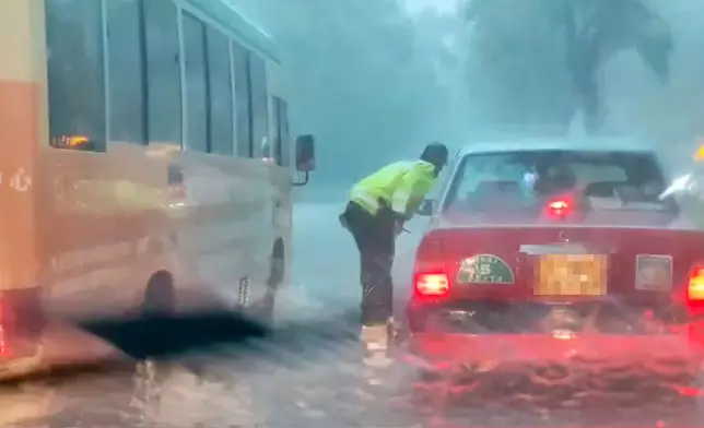 清水灣暴雨突現水浸，交通警冒雨指揮車流。網上片段截圖