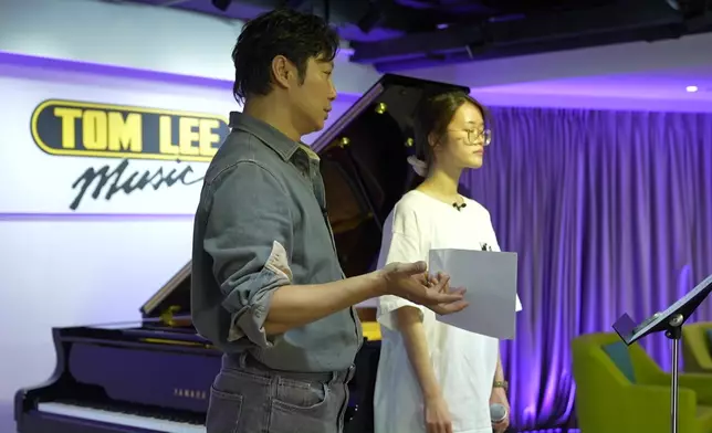 譚耀文細心指導布子殷（布子）唱歌。