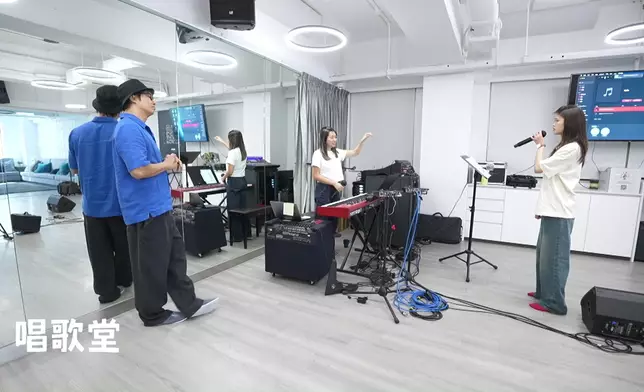 譚耀文細心指導布子殷（布子）唱歌。