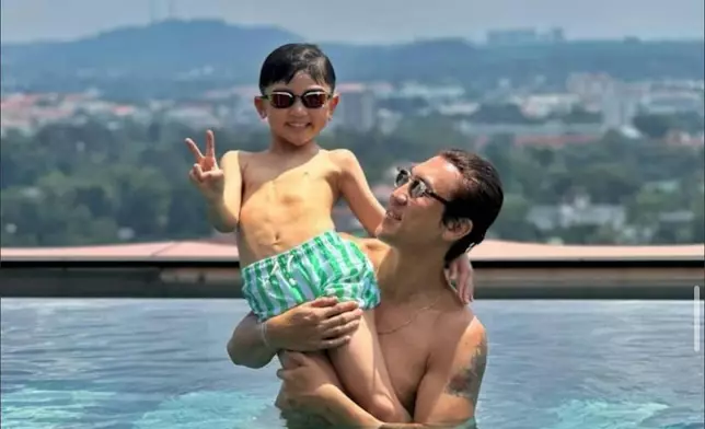 一家在泳池玩水。