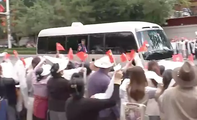 習近平在專車向觀送群眾揮手。央視截圖