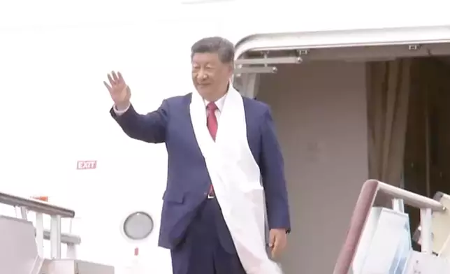 習近平登機前向民眾致意。央視截圖