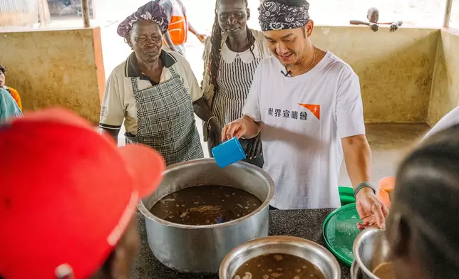 吳浩康小心翼翼地協助派發熱餐予難民。