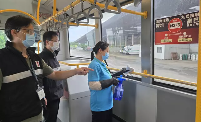 港口衞生科人員向跨境巴士公司承辦商人員建議加強清潔跨境巴士，以防止蚊子滋生。 政府新聞處圖片