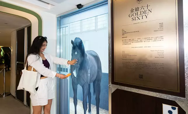 內地旅客張小姐與3D數碼技術還原的三屆香港馬王「金鎗六十」在虛擬馬房中互動