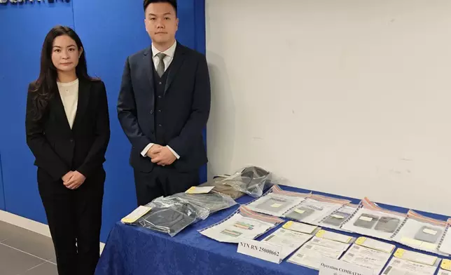 警方新界北總區科技及財富罪一案組總督察王玉欣（左）及高級督察盧震綱（右）展示證物。