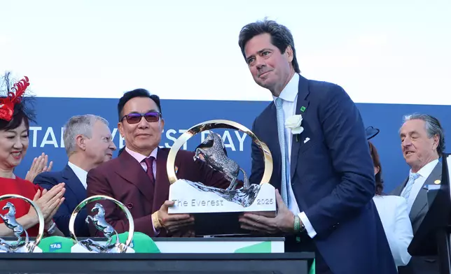 「嘉應高昇」的馬主團體代表梁錫光，在頒獎禮上接過珠穆朗瑪峰錦標冠軍獎盃。