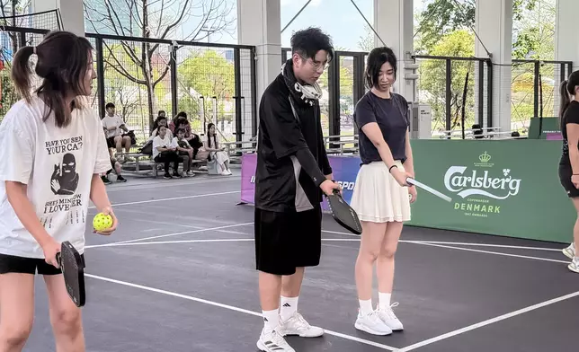 Alfred認真指導歌迷打匹克球。