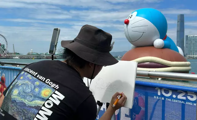 維港海上大巡遊展出巨型雕塑，有市民來寫生。巴士的報記者攝