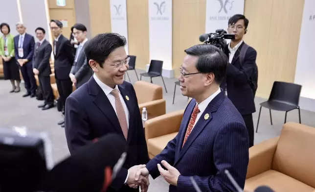 李家超（右）與新加坡總理黃循財（左）握手。李家超FB