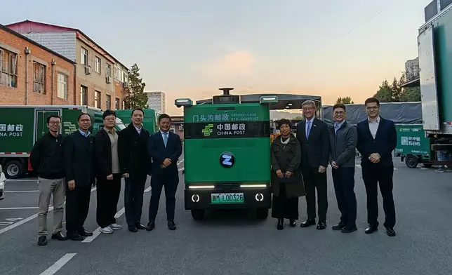 任景信（右三）及引進辦執行總裁彭文俊（左四）參觀一家自動駕駛技術企業於北京門頭溝郵政局的實地應用場景。政府新聞處圖片