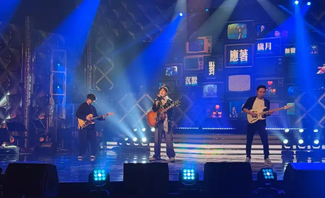 胡子貝彈埋結他畀大家睇。