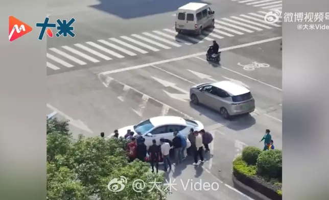 女子遭私家車撞倒捲入車底獲逾20名熱心民眾合力抬車救出送醫。影片截圖