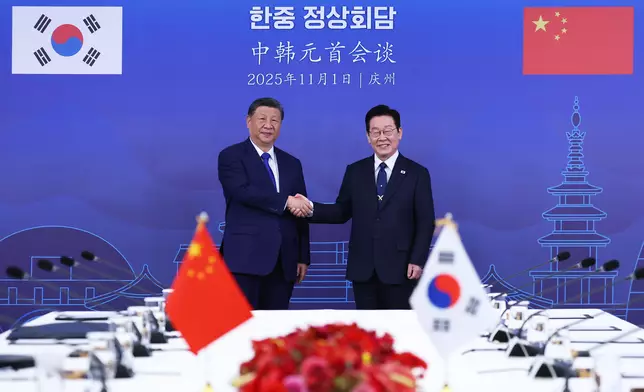 習近平（左）和李在明（右）握手。AP圖片