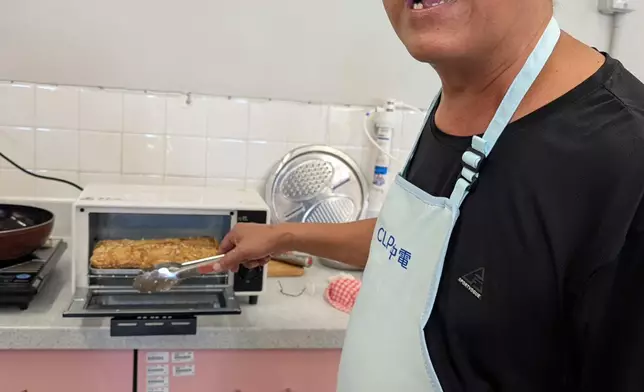 元朗攸壆路簡約公屋居民林先生率先體驗「電器圖書館」，試用電焗爐為家人炮製美食。
