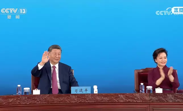 習近平（左）和夫人彭麗媛向在場人士揮手。央視截圖