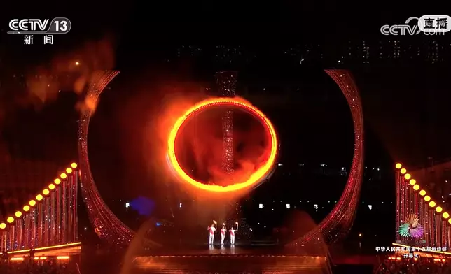 三名火炬手燃點主火炬。央視圖片
