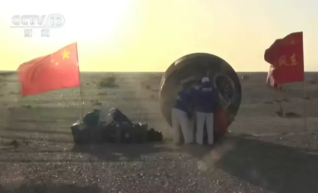 工作人員協助航天員出艙。央視截圖