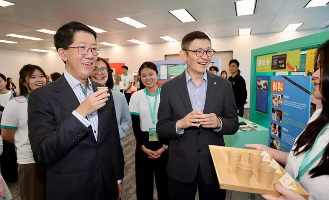 社會福利署署長杜永恒（左）及香港賽馬會董事羅碩瀚（右）與參與 21C@JC 計劃嘉年華的年輕人交流。香港賽馬會圖片