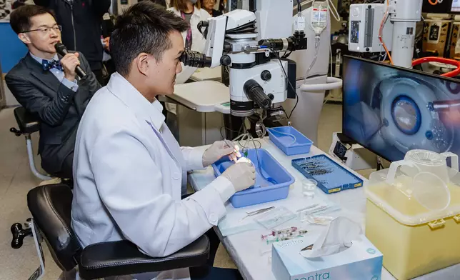青年眼科醫生司徒家浩，即場使用模型眼示範玻璃體切割手術操作， 中大眼科及視覺科學學系主任譚智在旁解說。