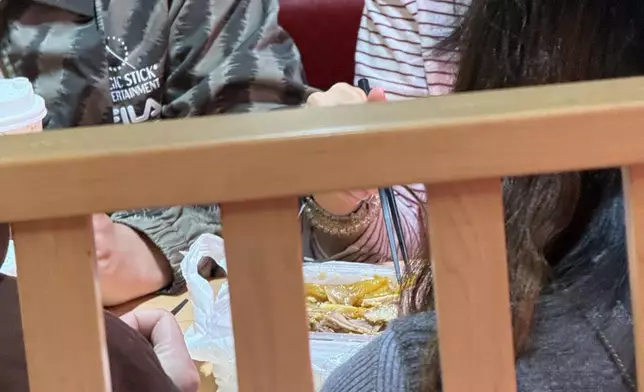 4名食客在店內的卡位享用由其它店舖外賣的手撕雞、薯條和杯裝飲品。網上圖片