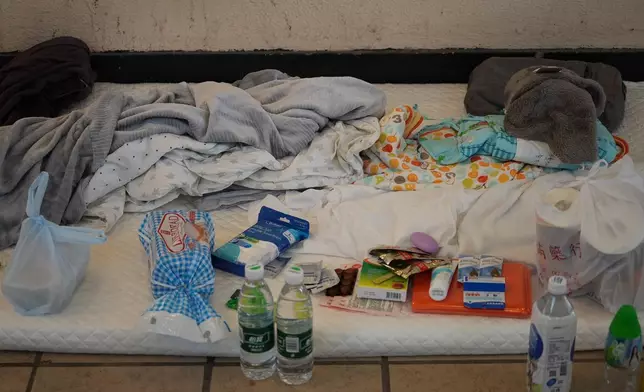 部分居民在商場及屋邨公共空間搭建簡易地鋪休息，床褥旁放有水、餅乾、衛生用品等。巴士的報記者攝