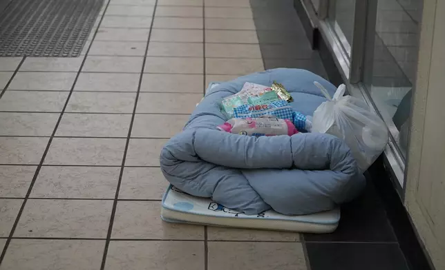 部分居民在商場及屋邨公共空間搭建簡易地鋪休息，床褥旁放有水、餅乾、衛生用品等。巴士的報記者攝