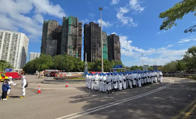 警方「災難遇害者辨認小組」（DVIU）在大埔宏福苑五級火現場外列隊。巴士的報記者攝