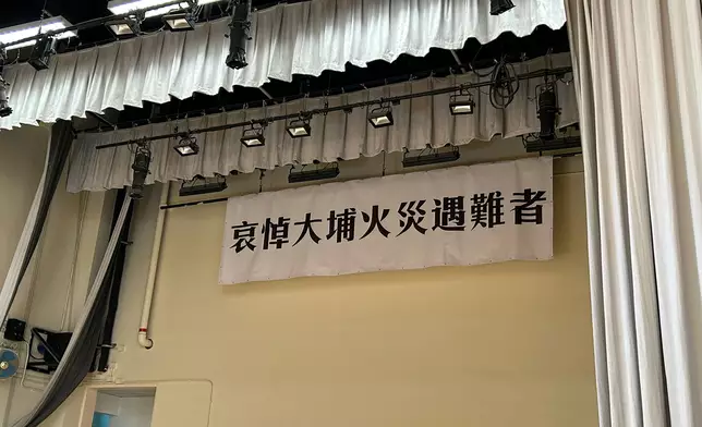 市民到弔唁處簽署弔唁冊，弔冊處前方擺放了白花，背後掛上悼念橫幅。巴士的報記者攝