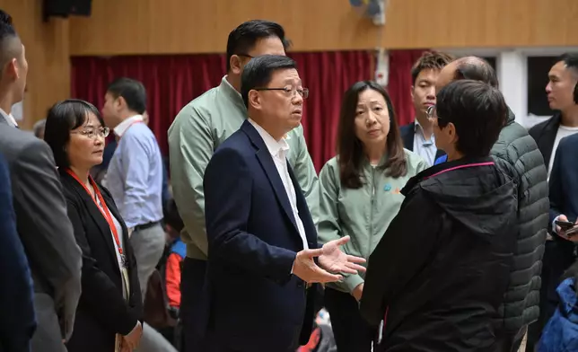 李家超（中）前往臨時庇護中心探望大埔宏福苑五級火警受影響居民。 政府新聞處圖片