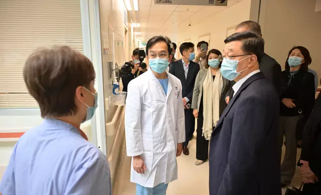 李家超（右）到威爾斯親王醫院探望​大埔宏福苑五級火警傷者。 政府新聞處圖片