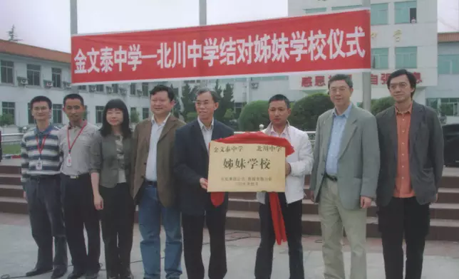 金文泰校長李國佳(左五)和北川校長劉亞春(右三)在簽約後，手捧四川長虹郭德軒(左四)和香港新駿楊向杰(右二)共贈的締結姊妹學校銅牌。現此牌在金文泰中學校史館收藏。(2009)楊向杰供相