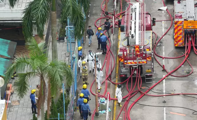 藍衫的消防巡查人員進入火場。巴士的報記者攝