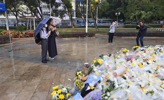 大埔五級火，市民在雨中獻花。巴士的報記者攝