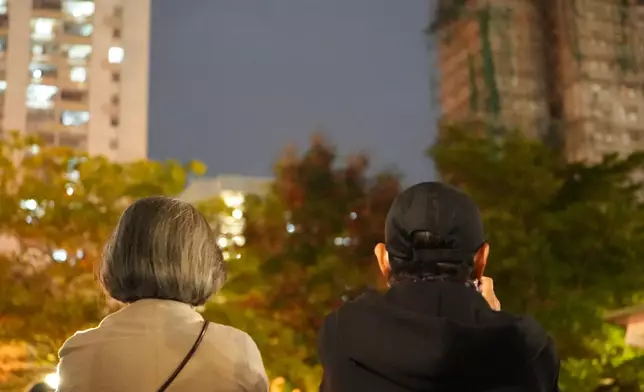 大埔五級火後，兩位年長市民看著薰黑的大廈，無聲慨嘆。巴士的報記者攝