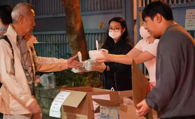 有市民向獻花人士送上齋飯。巴士的報記者攝