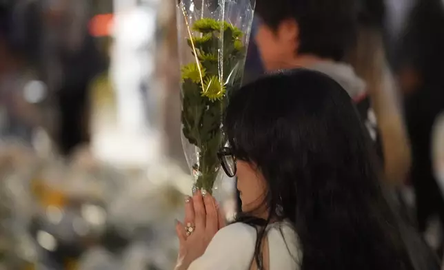 市民拿著花默默祝禱。巴士的報記者攝