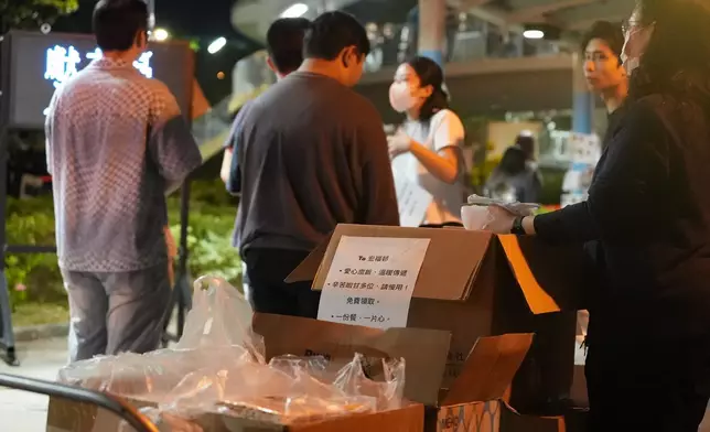 有市民向獻花人士送上齋飯。巴士的報記者攝