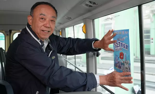 香港專線小巴持牌人協會會長馬僑生為小巴貼上海報。