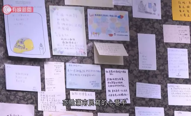 殉職消防員何偉豪設靈，殯儀館牆上貼滿心意卡、繪畫、信件致敬。有線新聞短片截圖