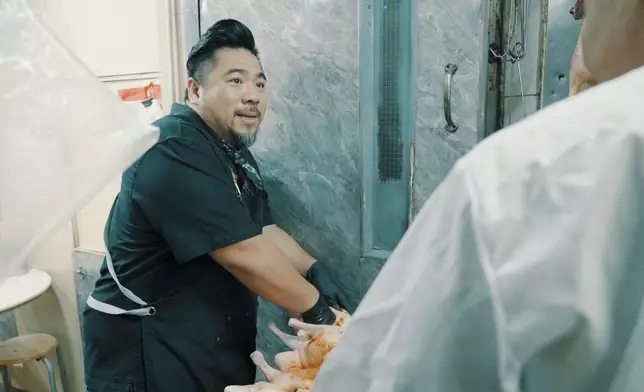 Christian幫手醃製燒鵝。