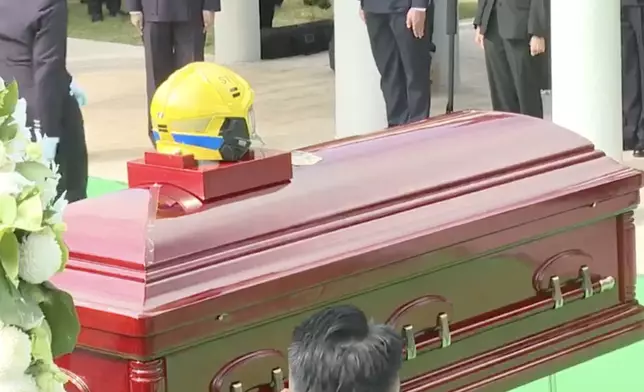 何偉豪生前用過的頭盔陪伴他長埋浩園。消防處直播截圖