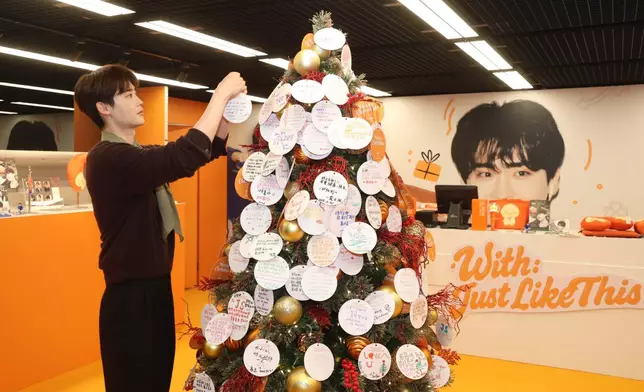 李鍾碩親手為聖誕樹掛上祝福語。主辦單位提供圖片