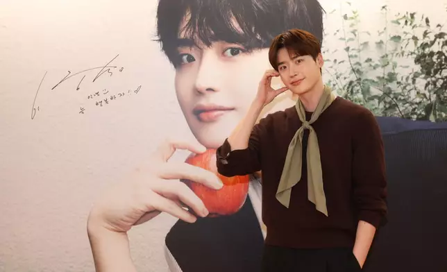 李鍾碩在自己佈景板上簽名，留下給香港粉絲的說話。主辦單位提供圖片