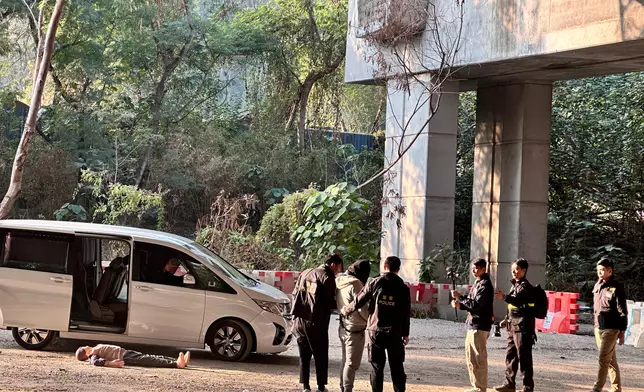 洪水橋亦園路謀殺案，警方押解其中一名被捕男子到事發位置重組案情。