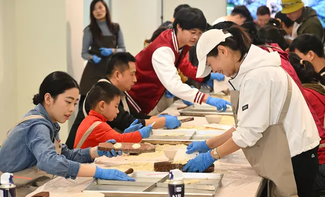 遊人學習製餅。政府新聞網圖片