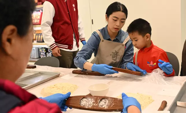 遊人學習製餅。政府新聞網圖片