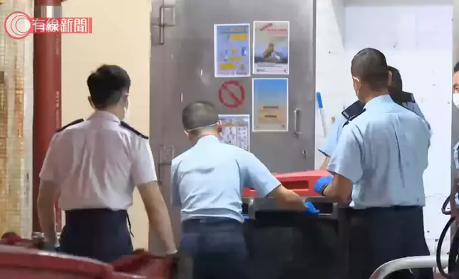 警員在垃圾房外蒐證。有線新聞影片截圖