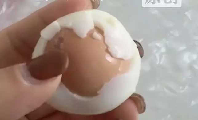 女子剝開水煮蛋發現裏面竟藏帶殼完整雞蛋。影片截圖